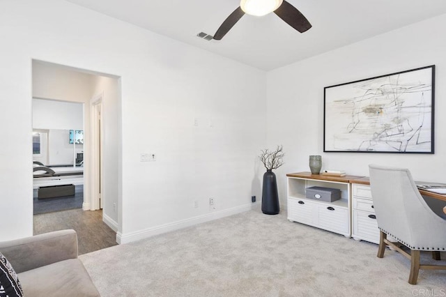 office space with baseboards, a ceiling fan, visible vents, and carpet