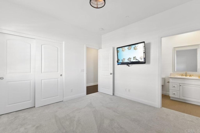 unfurnished bedroom featuring carpet floors, a sink, and baseboards