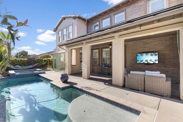 rear view of house featuring a patio area, a pool with connected hot tub, and stucco siding