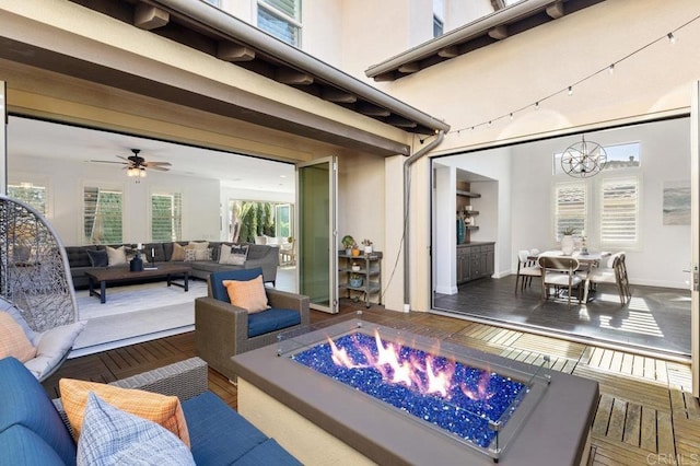 view of patio / terrace with an outdoor living space with a fire pit and ceiling fan