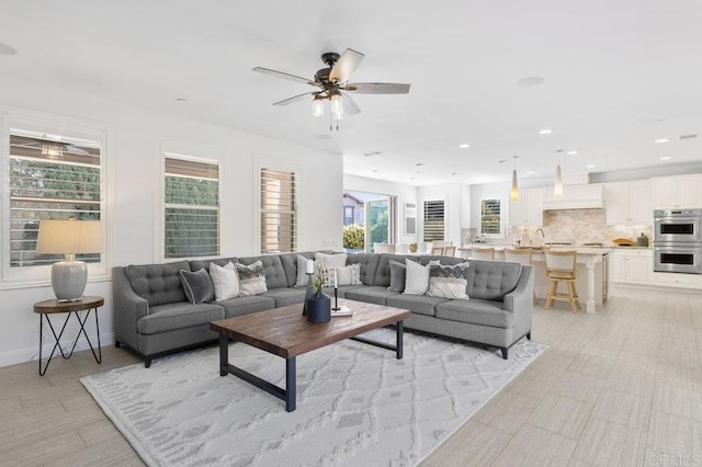 living area with a ceiling fan, baseboards, and recessed lighting