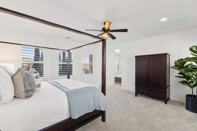 bedroom with baseboards, visible vents, light colored carpet, and multiple windows