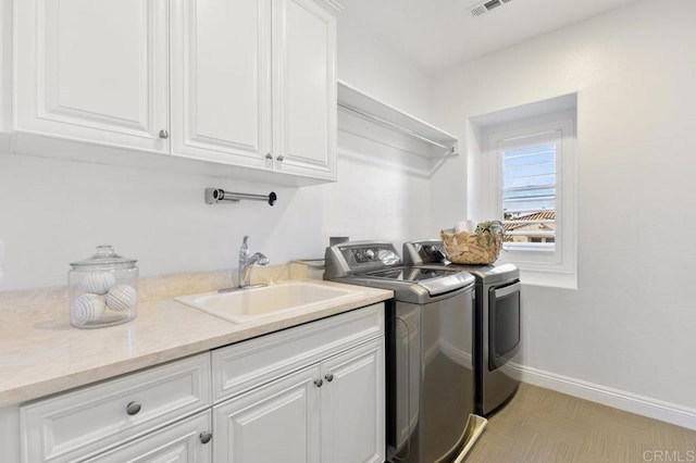 laundry room with separate washer and dryer, baseboards, cabinet space, and a sink