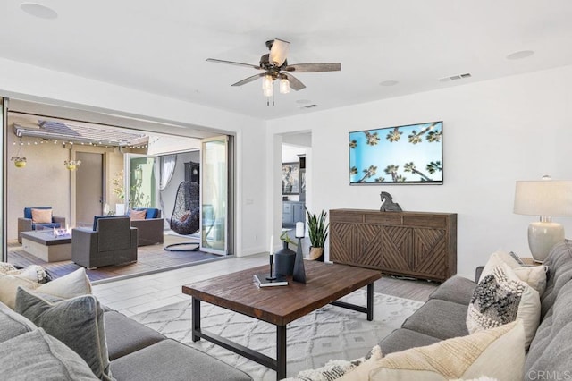 living room featuring wood finished floors, visible vents, and ceiling fan
