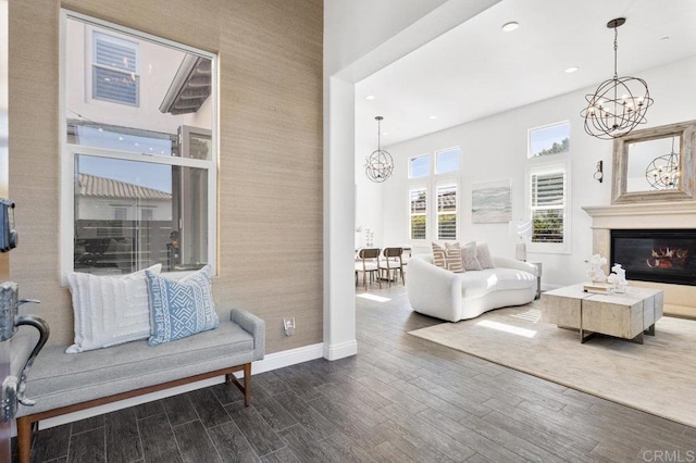 living room featuring a chandelier, dark wood finished floors, baseboards, and recessed lighting