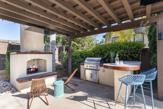 715 Blossom Rd, Encinitas, CA 92024 - view of patio featuring a lit fireplace, area for grilling, and a bar