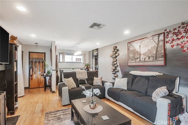living area with visible vents, light wood-style flooring, and recessed lighting