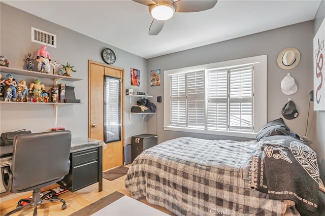 bedroom with light wood-style flooring, visible vents, and ceiling fan