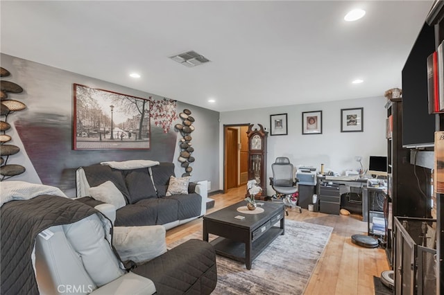 living area featuring light wood-style floors, recessed lighting, and visible vents
