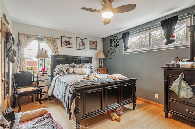 bedroom with light wood-style flooring, multiple windows, and a ceiling fan