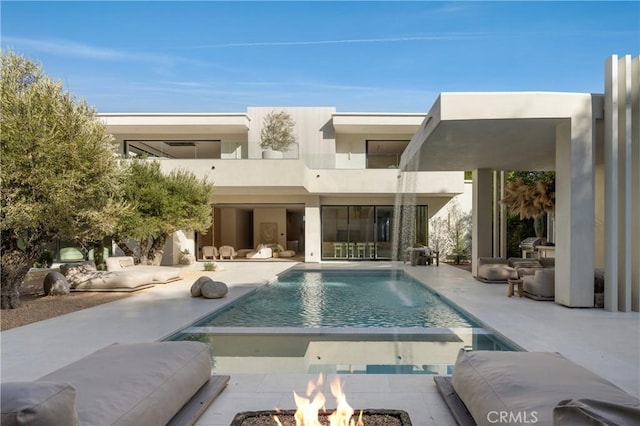 17177 Adlon Rd, Encino, CA 91436 - back of property featuring a pool with connected hot tub, a balcony, a patio, a fire pit, and stucco siding