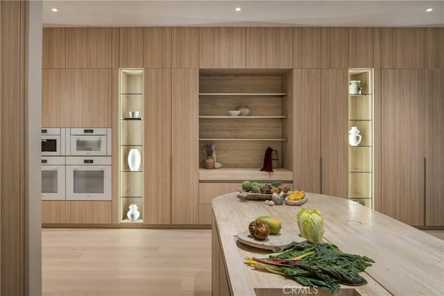 17177 Adlon Rd, Encino, CA 91436 - kitchen featuring light countertops, light wood-style flooring, modern cabinets, and white double oven