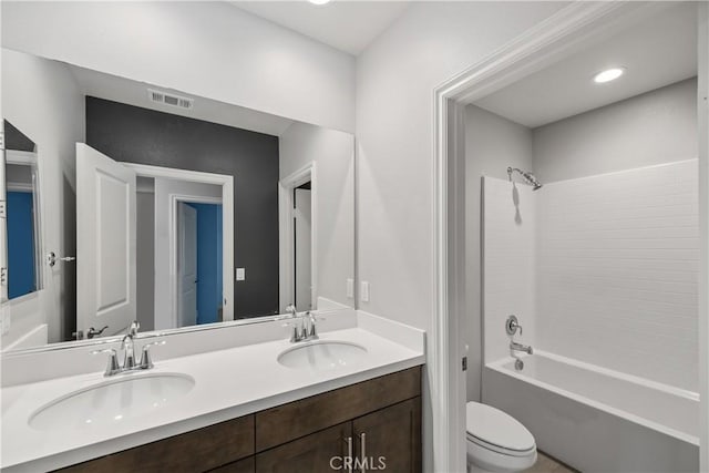 full bathroom with toilet, a sink, visible vents, and double vanity