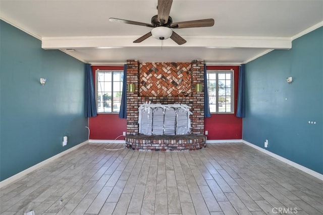 living area featuring wood finished floors, a brick fireplace, baseboards, a ceiling fan, and crown molding
