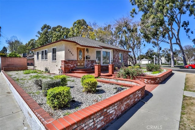 view of front of property featuring stucco siding and fence