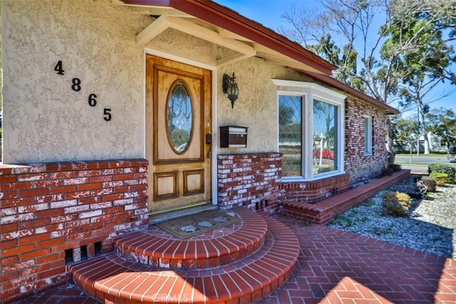 entrance to property featuring stucco siding