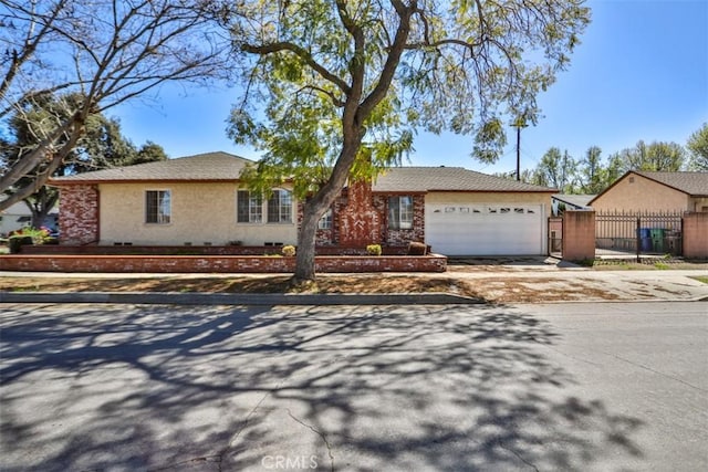 ranch-style house featuring driveway, fence, and an attached garage