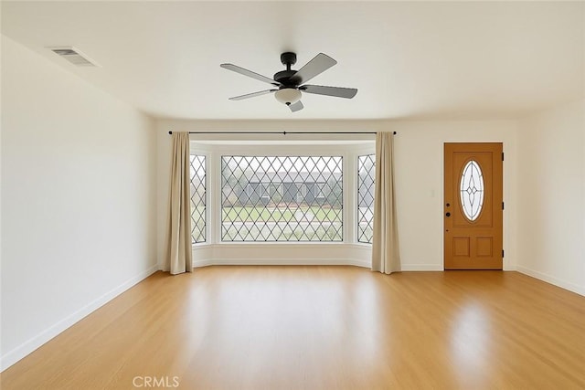 foyer with light wood finished floors, visible vents, ceiling fan, and baseboards