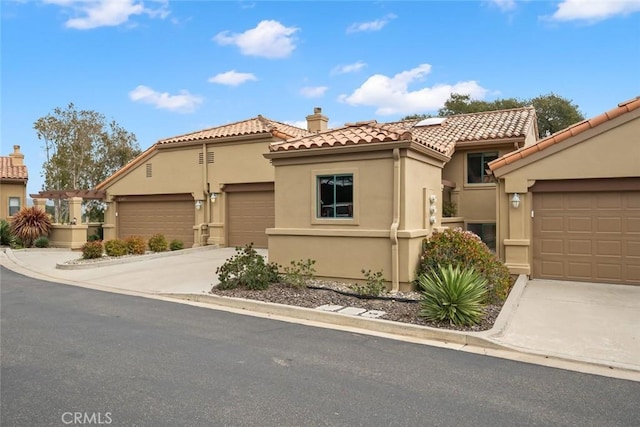 2344 Snowberry Ct, Avila Beach, CA 93424 - mediterranean / spanish-style home with stucco siding, a chimney, a tiled roof, and concrete driveway