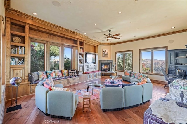2695 Shady Ridge Ln, Diamond Bar, CA 91765 - living room featuring built in shelves, crown molding, wood-type flooring, ceiling fan, and a glass covered fireplace