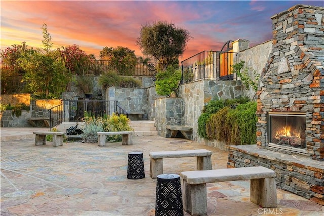 2695 Shady Ridge Ln, Diamond Bar, CA 91765 - patio terrace at dusk featuring an outdoor stone fireplace, a patio, and stairs