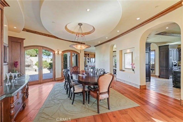 2695 Shady Ridge Ln, Diamond Bar, CA 91765 - dining space featuring arched walkways, crown molding, a tray ceiling, french doors, and light wood-type flooring