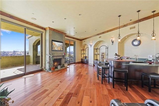 2695 Shady Ridge Ln, Diamond Bar, CA 91765 - bar with arched walkways, crown molding, a fireplace, wood finished floors, and decorative light fixtures