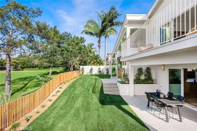 view of yard featuring a patio area, a fenced backyard, and a balcony