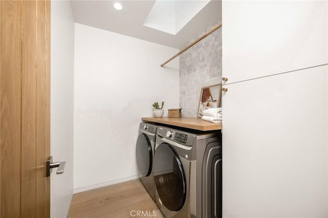 clothes washing area featuring washing machine and dryer, recessed lighting, laundry area, and light wood-style flooring