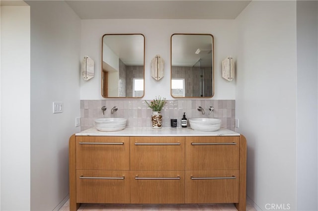 bathroom with a sink, backsplash, and double vanity