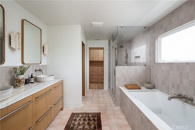 bathroom with a shower stall, a garden tub, a sink, and double vanity