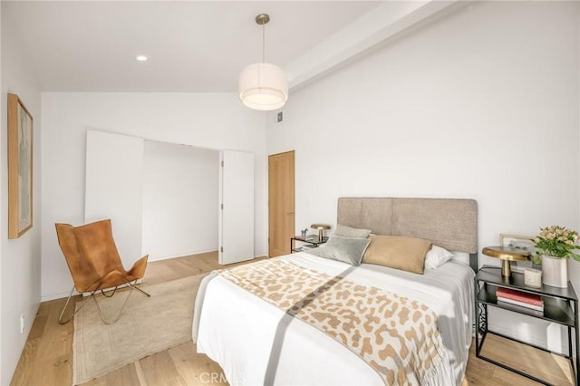 bedroom with high vaulted ceiling, a closet, visible vents, and light wood-style flooring