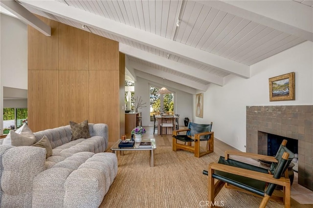 living area featuring lofted ceiling with beams, light wood-style floors, and a fireplace