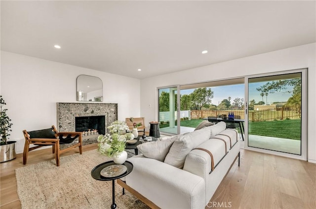 living room featuring a fireplace, recessed lighting, and light wood-type flooring