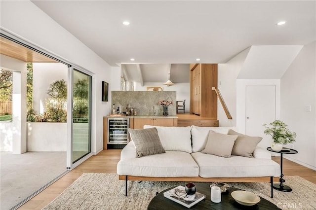 living area with recessed lighting, light wood-style floors, beverage cooler, and indoor wet bar