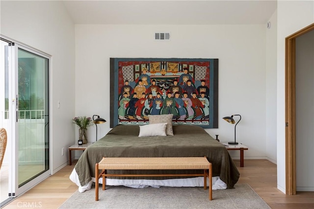 bedroom with light wood-type flooring, visible vents, baseboards, and access to exterior
