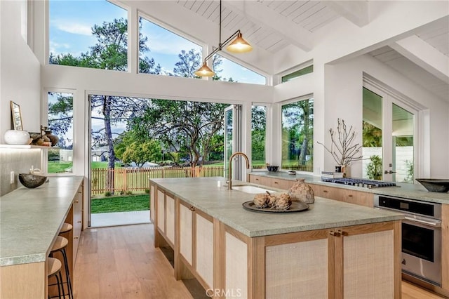 sunroom with beam ceiling and a sink