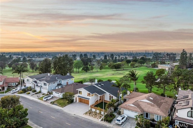 aerial view at dusk featuring a residential view and golf course view