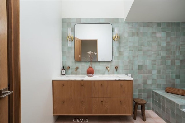 bathroom featuring tile walls, a sink, and double vanity