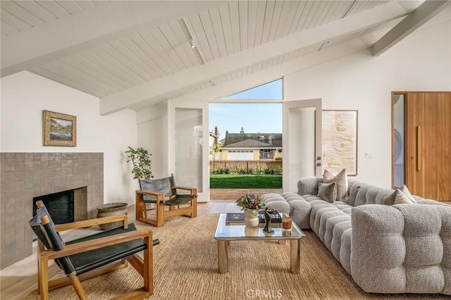 living room with a fireplace, wood finished floors, vaulted ceiling with beams, and wooden ceiling