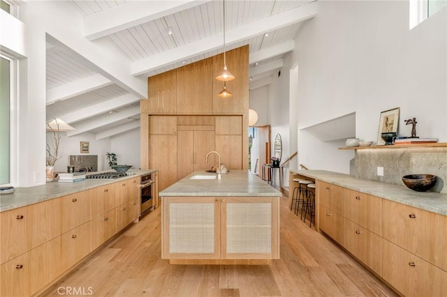 kitchen featuring stainless steel appliances, vaulted ceiling with beams, wooden ceiling, light brown cabinets, and a sink
