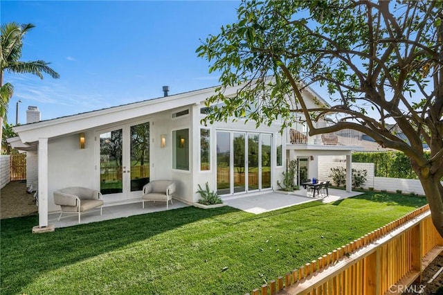 back of house featuring stucco siding, a fenced backyard, french doors, and a patio
