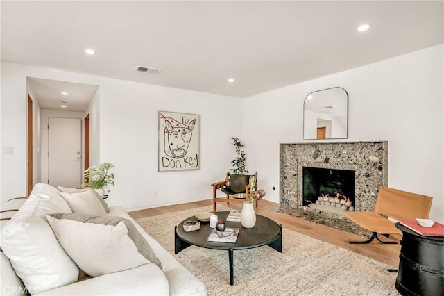 living area with visible vents, a fireplace, wood finished floors, and recessed lighting
