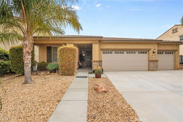 view of front of house featuring driveway, stucco siding, an attached garage, and stone siding
