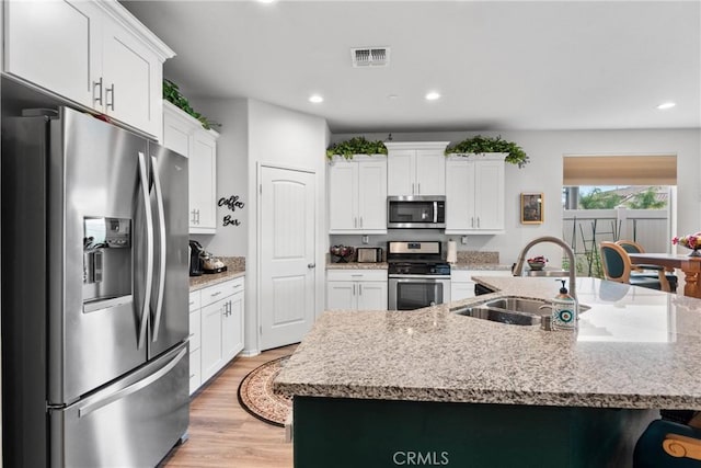 kitchen with a sink, white cabinetry, stainless steel appliances, visible vents, and recessed lighting