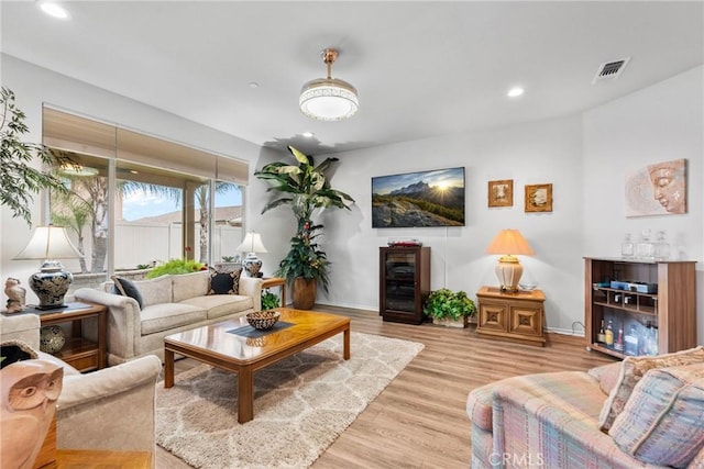 living area with visible vents, baseboards, light wood-style floors, and recessed lighting