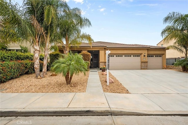 view of front of home featuring stucco siding, driveway, a garage, and stone siding