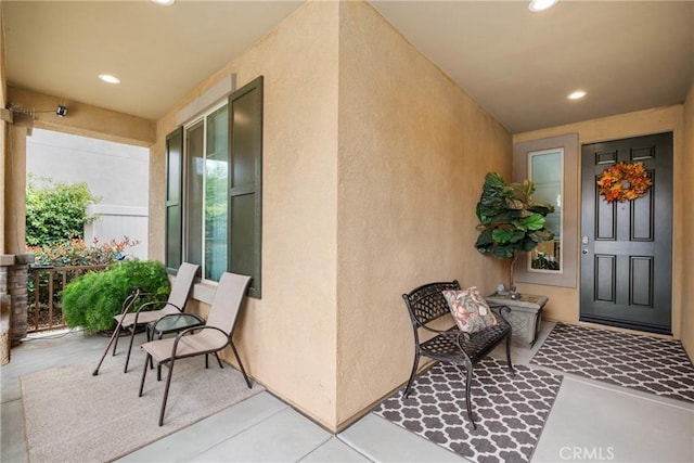 doorway to property featuring stucco siding and a porch