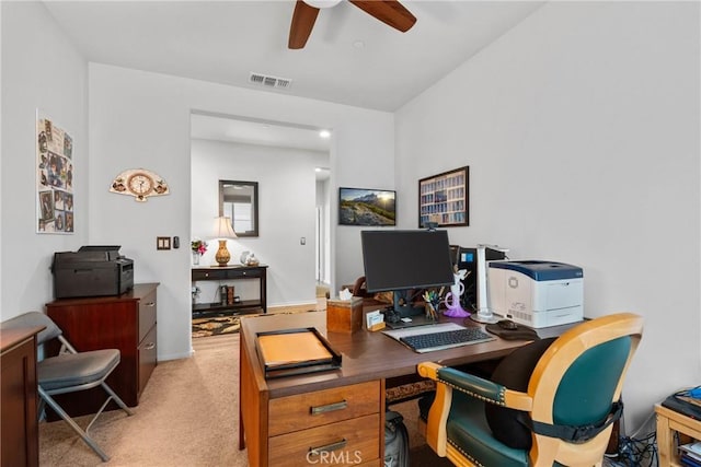 home office featuring light colored carpet, visible vents, and a ceiling fan