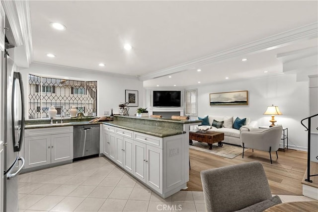 kitchen featuring ornamental molding, stainless steel appliances, a peninsula, and open floor plan